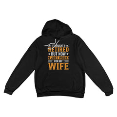 Black pullover hoodie featuring 'I Thought I Retired, But Now I Just Work for My Wife' design in bold orange and white lettering.