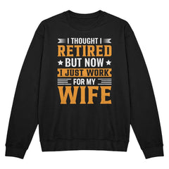 Black crewneck sweatshirt with 'I Thought I Retired, But Now I Just Work for My Wife' text in bold orange and white print.